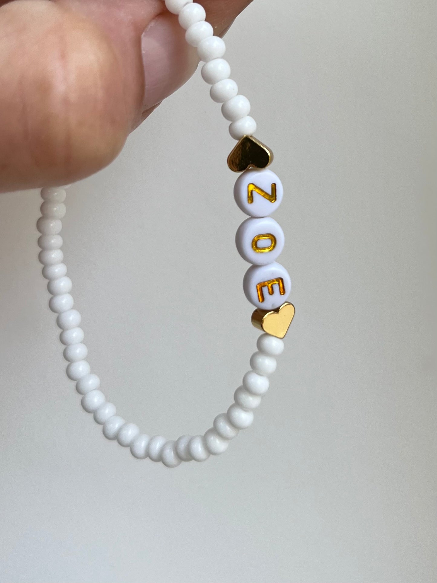 White beaded personalised bracelet with gold heart-shaped beads
