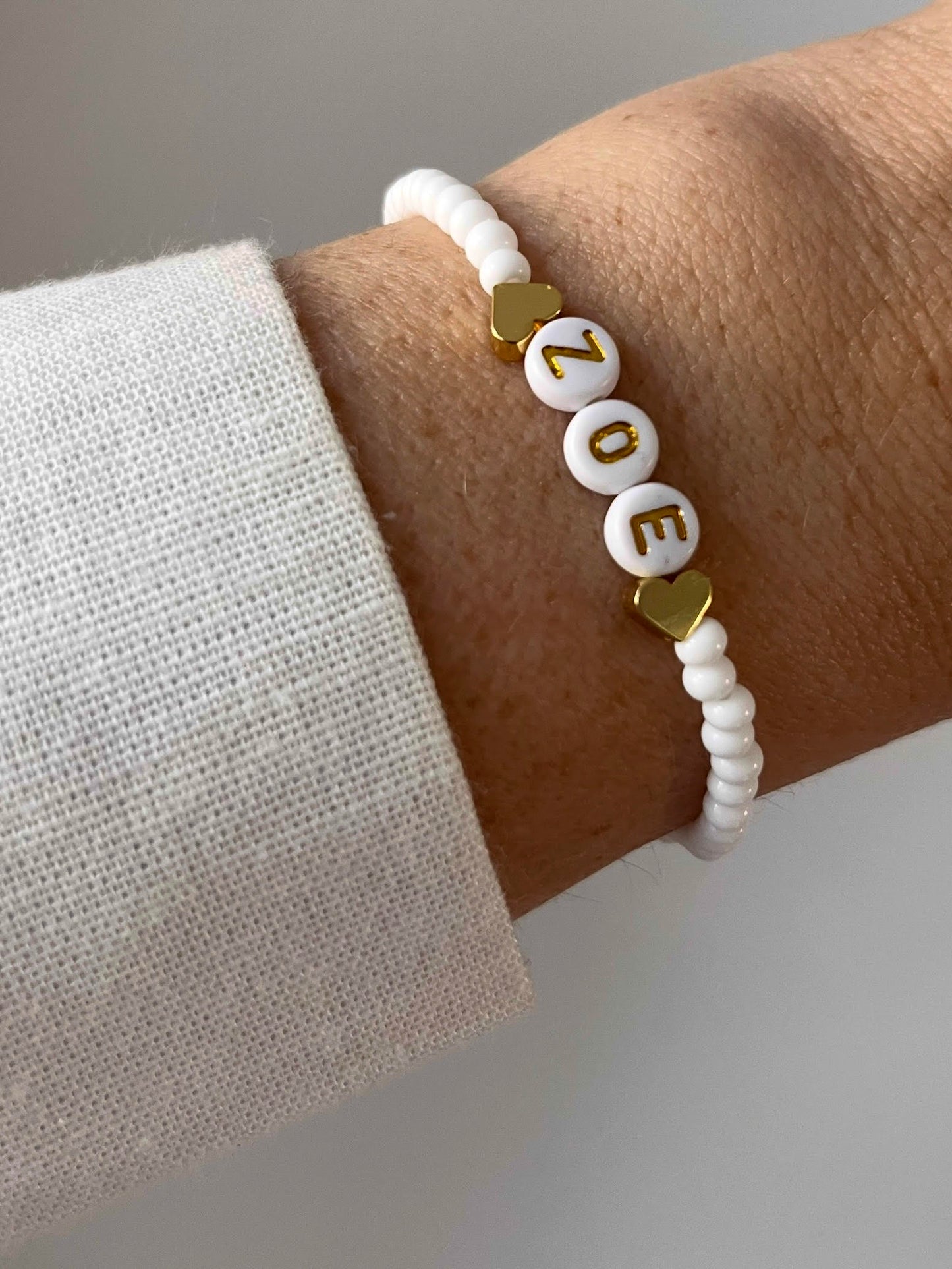 White beaded personalised bracelet with gold heart-shaped beads